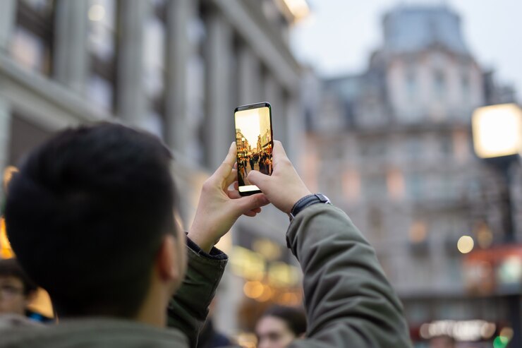 tourist man taking pictures with cell phone with building 42667 1181 Jelajahi Dunia Fotografi dengan Memilih Gadget Terbaik yang Akan Membantu Merekam Tiap Momen Berharga